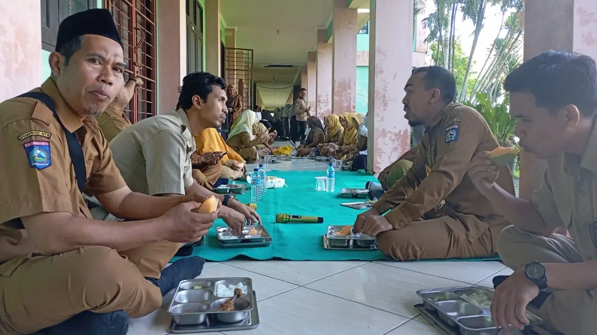 Para pendidik dan tenaga kependidikan menikmati program MBG di sekolah setempat, Selasa (14/4).


