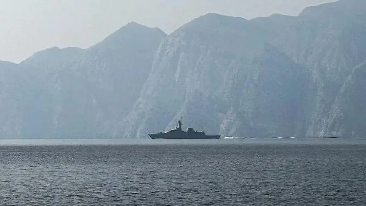 Sebuah kapal perang terlihat berlayar di Selat Hormuz, jalur perairan vital yang dilalui sebagian besar pasokan minyak dan gas dunia.