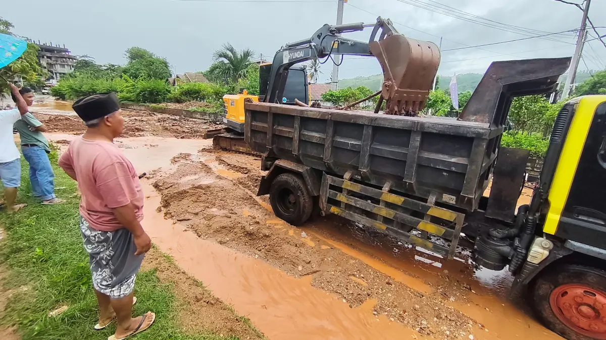 Sebuah truk mengangkut sisa lumpur yang terbawa saat hujan dari atas perbukitan turun hingga ke badan jalan raya wisata Kuta, Desa Kuta, Lombok Tengah, beberapa waktu lalu.
