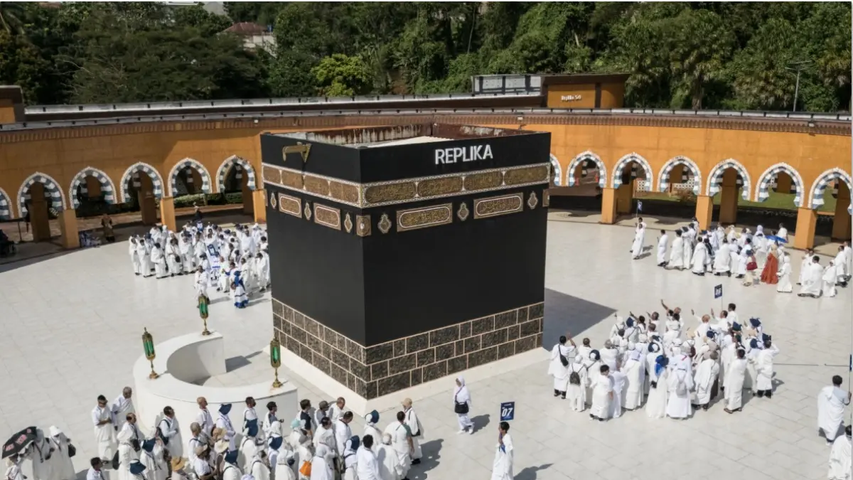 MANASIK: Para calon jamaah haji Indonesia berlatih ritual tawaf mengelilingi replika Kakbah di Pusat Pelatihan Manasik Al Mahmudah (AMTC) di Tangerang Selatan, Ahad (5/4). Pemerintah dan DPR menyepakati tambahan biaya penerbangan Rp 1,77 triliun akan ditanggung APBN. Tambahan biaya penerbangan ini muncul karena melonjaknya harga avtur akibat konflik Timur Tengah. (YASUYOSHI CHIBA / AFP)