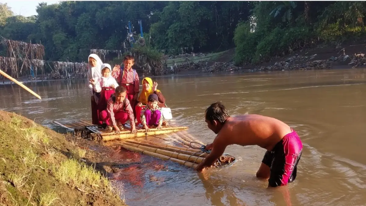 OPSI TERCEPAT: Siswa SDN Jubung 02 dan TK Budi Utomo Dusun Darungan Selatan Desa Jubung Jember terpaksa naik getek ke sekolah pada Rabu (15/4). (Jumai/Radar Jember Grup Jawa Pos)