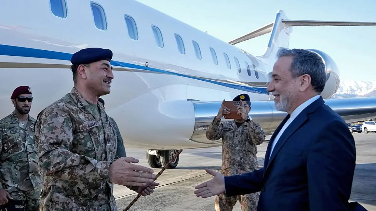 BAWA PESAN: Menlu Iran Abbas Araghchi (kanan) menyambut kedatangan Panglima Angkatan Darat Pakistan Marsekal Lapangan Asim Munir di bandara Teheran, Rabu (15/4). (KEMENTERIAN LUAR NEGERI IRAN / AFP)