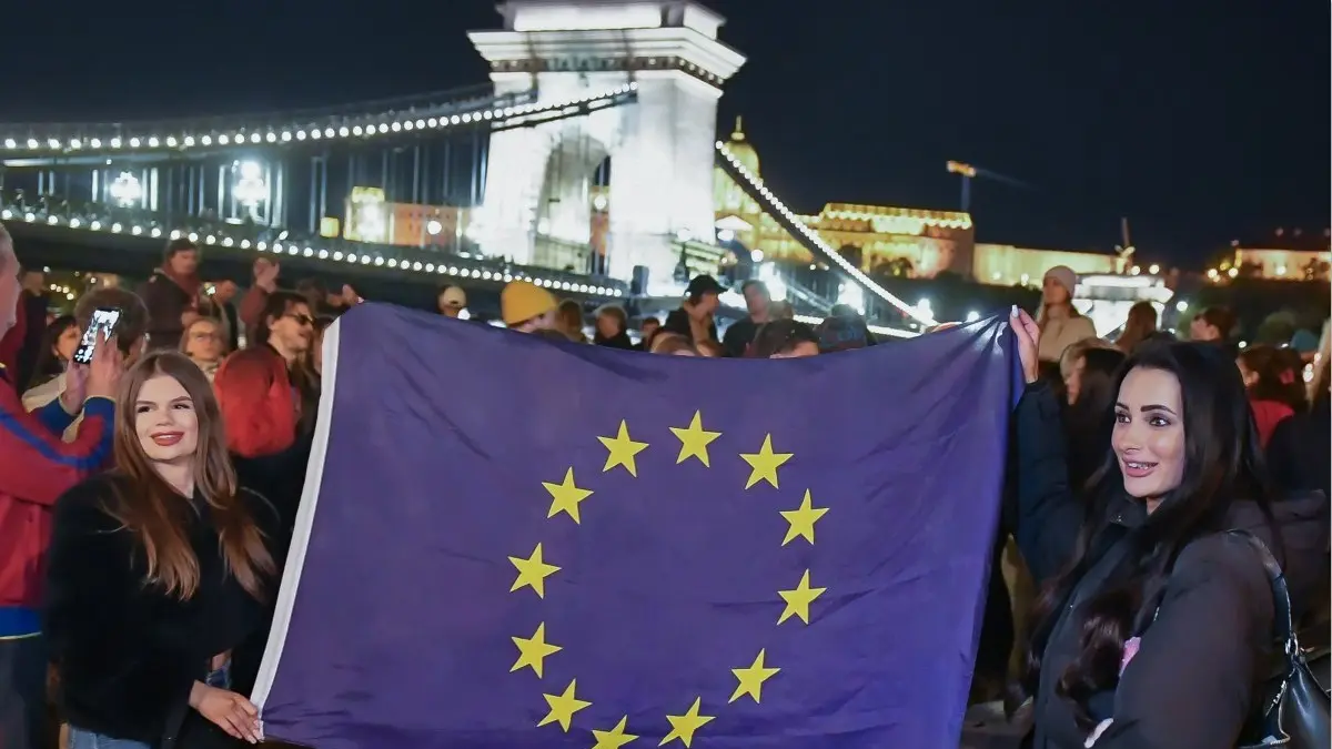 PROTES: Para warga mengibarkan bendera Uni Eropa di Hungaria, Senin (13/4). (FERENC ISZA/AFP)