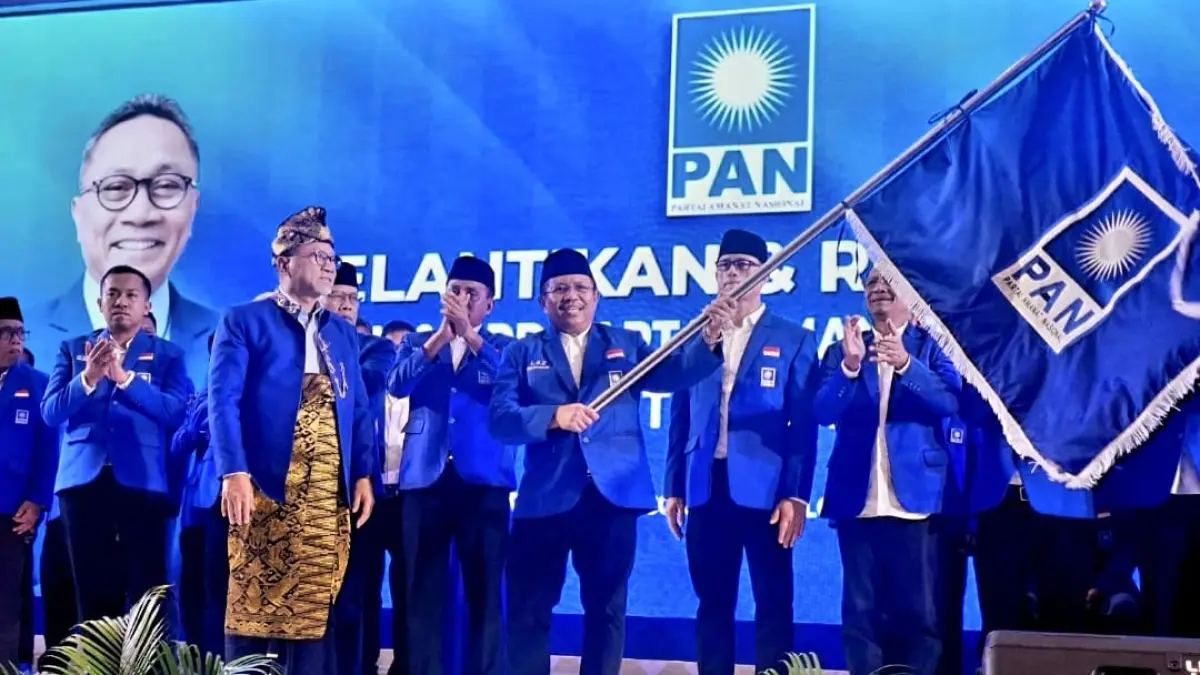 PENGUKUHAN: Ketua DPW PAN NTB Lalu Ahmad Zaini mengibarkan pataka PAN yang diserahkan Ketua Umum PAN Zulkifli Hasan dalam momen pelantikan pengurus DPW PAN NTB dan pengurus DPD PAN kabupaten/kota se-NTB di Hotel Prime Park Mataram, Jumat (17/4). (UMAR/LOMBOK POST)