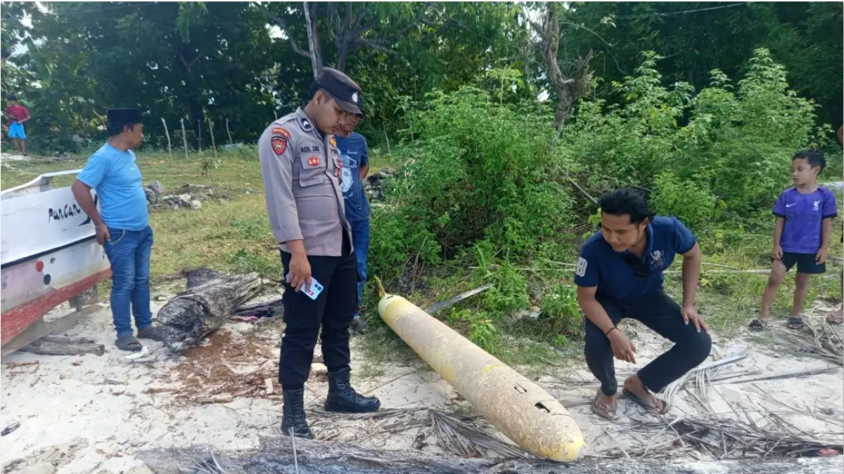MISTERIUS: Petugas mendatangi lokasi penemuan benda mirip rudal di pesisir Desa Torjek, Kecamatan Kangayan, Sumenep, Senin (20/4). (Polres Sumenep For Jawa Pos Grup)