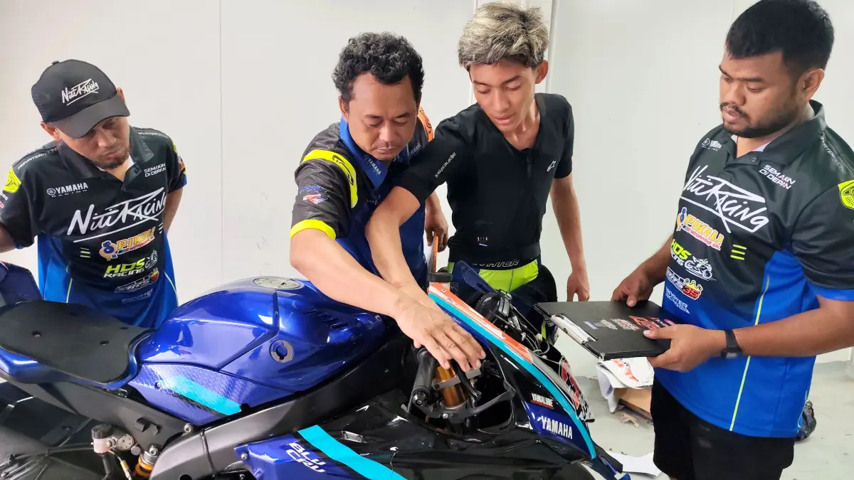 Pembalap NTB Arai Agaska Dibani Laksana ikut memeriksa kondisi motor balapnya bersama tim mekanik usai gagal tuntaskan balapan di kelas Nasional Super Sport 600 CC, Mandalika Racing Series 2026 di Sirkuit Internasional Mandalika, Lombok Tengah, Minggu (26/4). (Dewi/Lombok Post) 