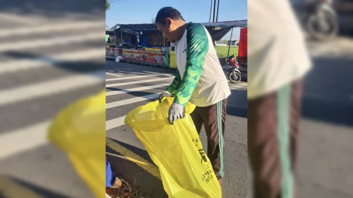 JAGA KEBERSIHAN: Petugas kebersihan DLH Kota Mataram saat membersihkan sampah jajanan di kawasan Asrama Haji. (CHIA/LOMBOK POST)