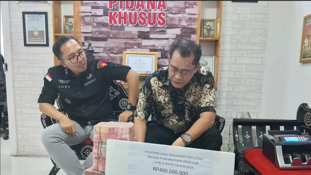 KOOPERATIF: Penasihat Hukum terdakwa korupsi Dana Pokir DPRD Lobar Ahmad Zainuri, Edy Rahman menandatangani berita acara penitipan uang pengganti kerugian negara yang diserahkan ke Kasi Pidsus Kejari Mataram I Made Juri Imanu di kantor kejari setempat. (HARLI/LOMBOK POST)