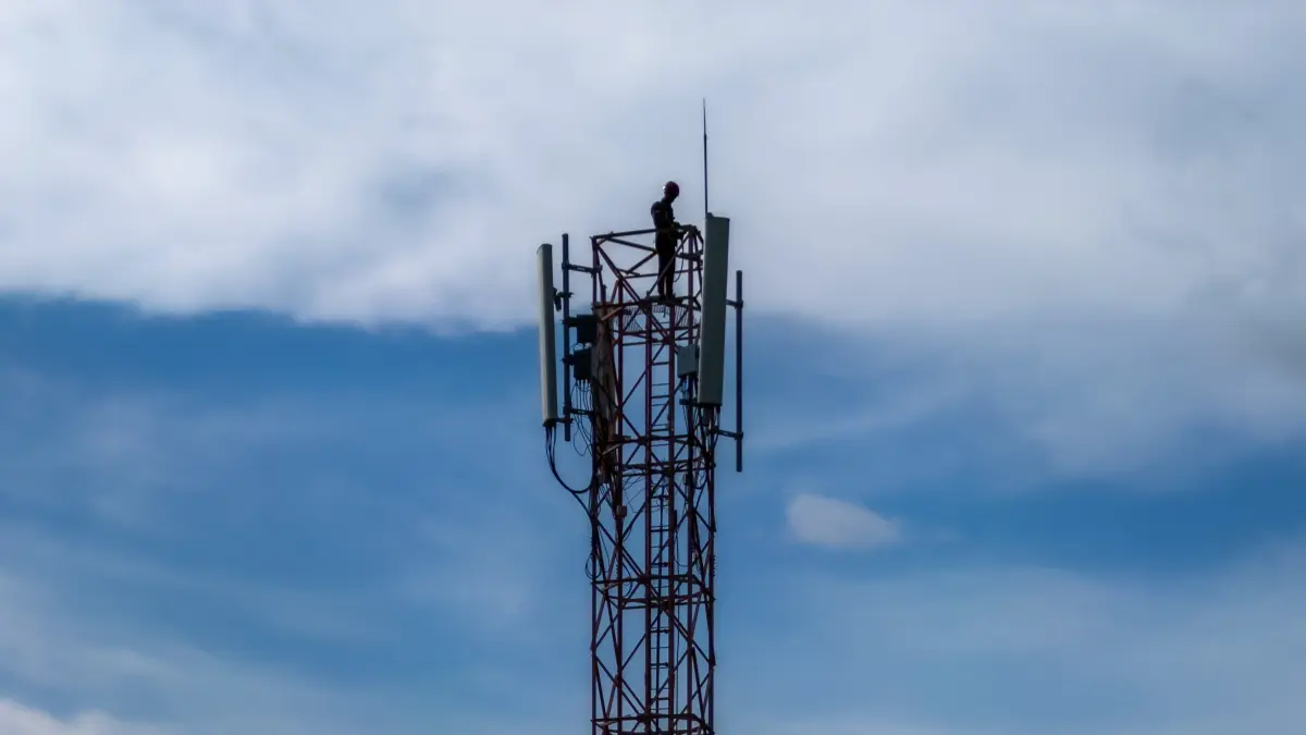 ILUSTRASI: Seorang pekerja memperbaiki menara telekomunikasi di salah satu titik Kota Mataram, beberapa waktu lalu. (IVAN/LOMBOK POST)