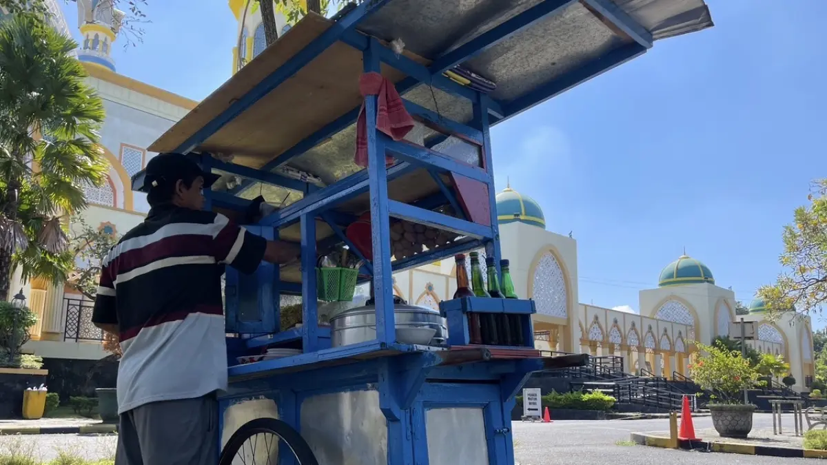 MENUNGGU PEMBELI: Musa, pedagang soto di kawasan Islamic Center Mataram, tetap bertahan menjajakan dagangannya di tengah naiknya harga bahan pokok dan sepinya pembeli di momen tertentu. (ZAD/LOMBOK POST)