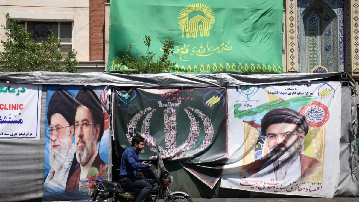 MULAI NORMAL: Para pengendara mobil melintas di depan gambar mendiang pemimpin tertinggi Iran, Ayatollah Ruhollah Khomeini, yang dipasang di sepanjang jalan di Teheran, Rabu (29/4). (ATTA KENARE / AFP)
