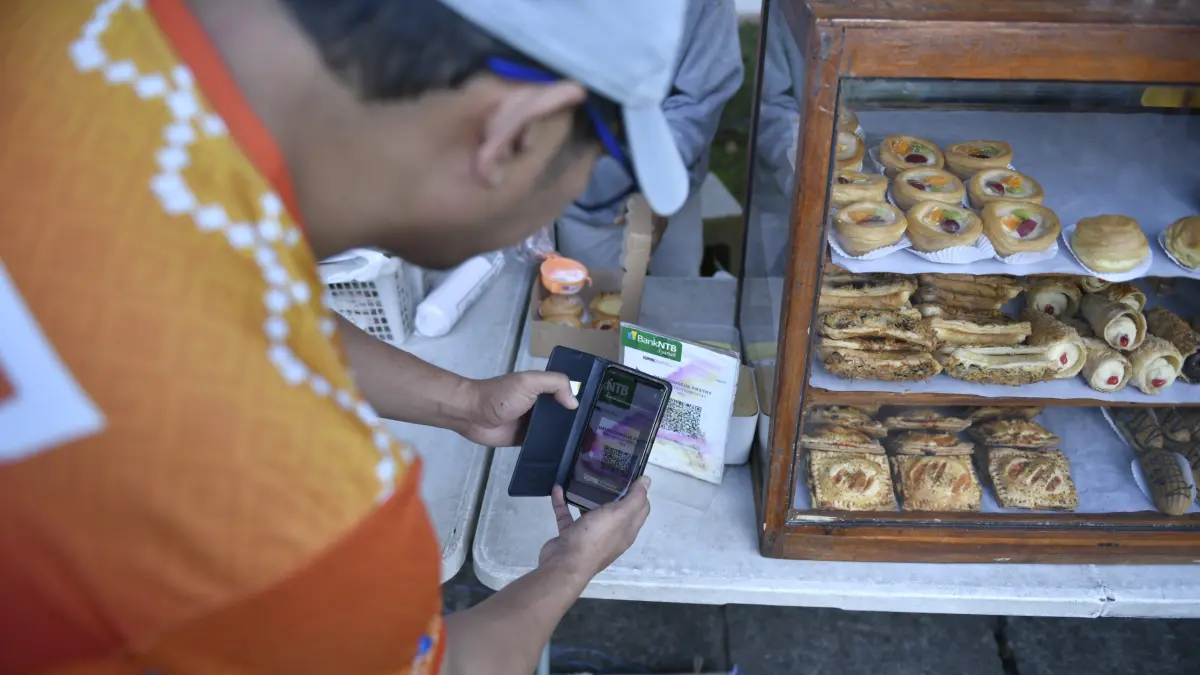 IMPLEMENTASI QRIS: Bank NTB Syariah kenalkan QRIS ke masyarakat luas dan mengajak penggunaannya untuk bertransaksi. (IST/LOMBOK POST)