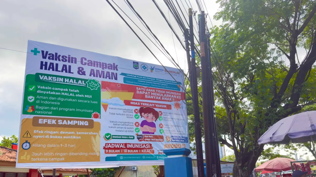 PENYAKIT MENULAR: Papan sosialisasi dan edukasi kepada masyarakat terkait vaksin campak yang halal dan aman, terpampang di salah satu ruas jalan di Kota Mataram, Senin (4/5). (YUYUN/LOMBOK POST)