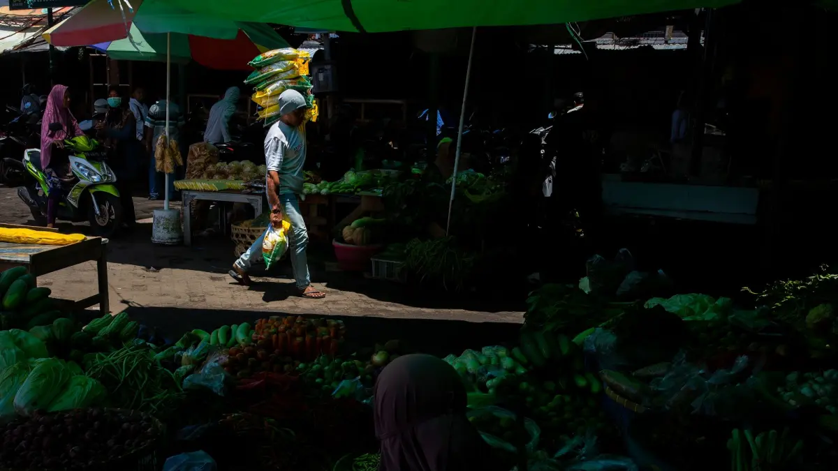 Salah seorang pekerja mengangkut beras SPHP ke dalam Pasar Kebon Roek, Ampenan, Mataram. (PUJO/LOMBOK POST)