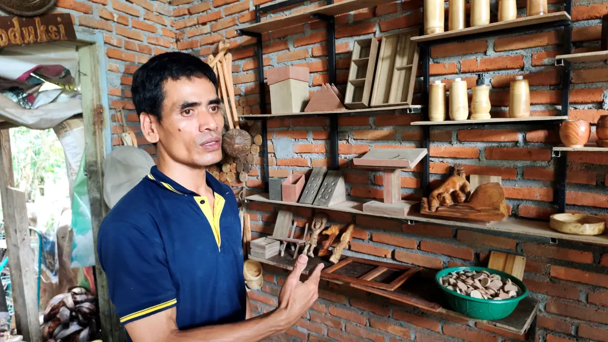 KARYA SENI: Lalu Surya Bakti tunjukkan aneka kerajinan limbah kayu yang terpajang di rumah produksinya di Desa Bonder, Kecamatan Praya Barat, Kabupaten Lombok Tengah, beberapa waktu lalu. (Istimewa)