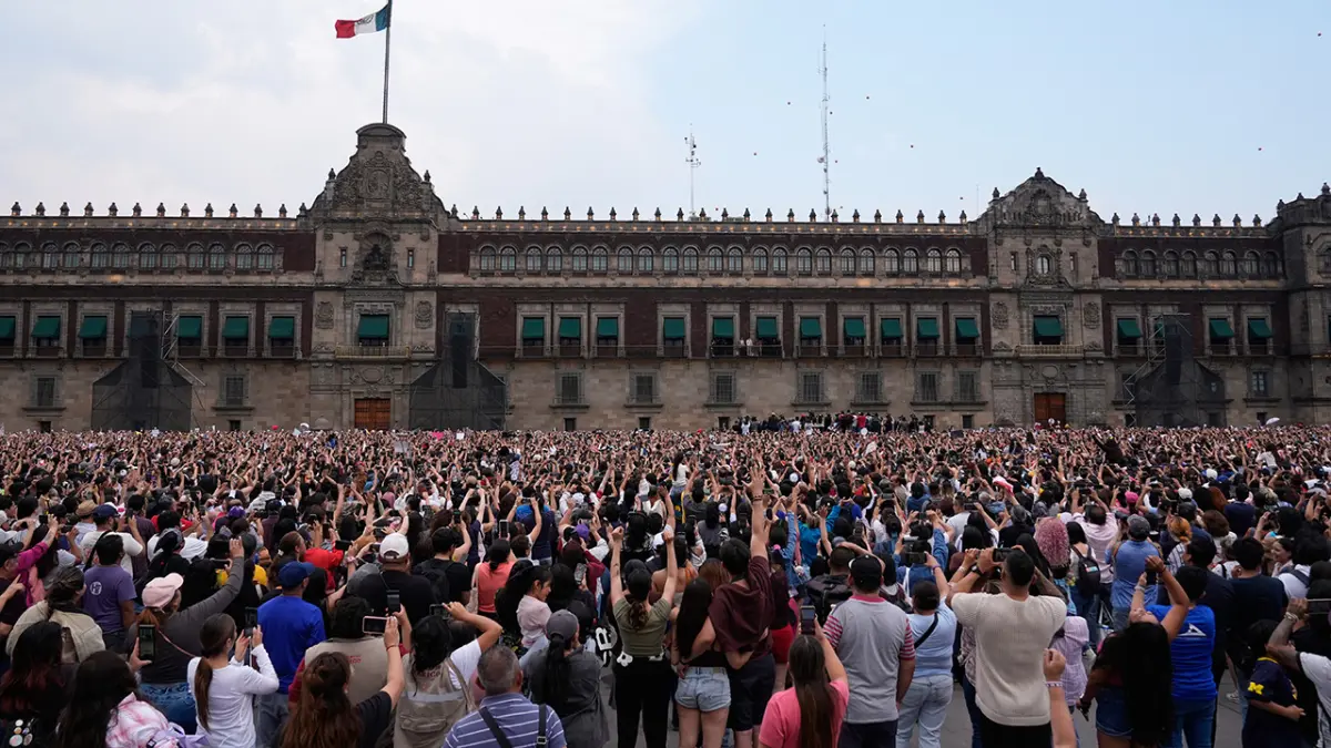 Para penggemar berkumpul di luar Istana Nasional saat para anggota grup musik asal Korea Selatan, BTS, melambaikan tangan bersama Presiden Meksiko Claudia Sheinbaum dari balkon di Mexico City, Rabu, (6/5). (AP Photo/Marco Ugarte)
