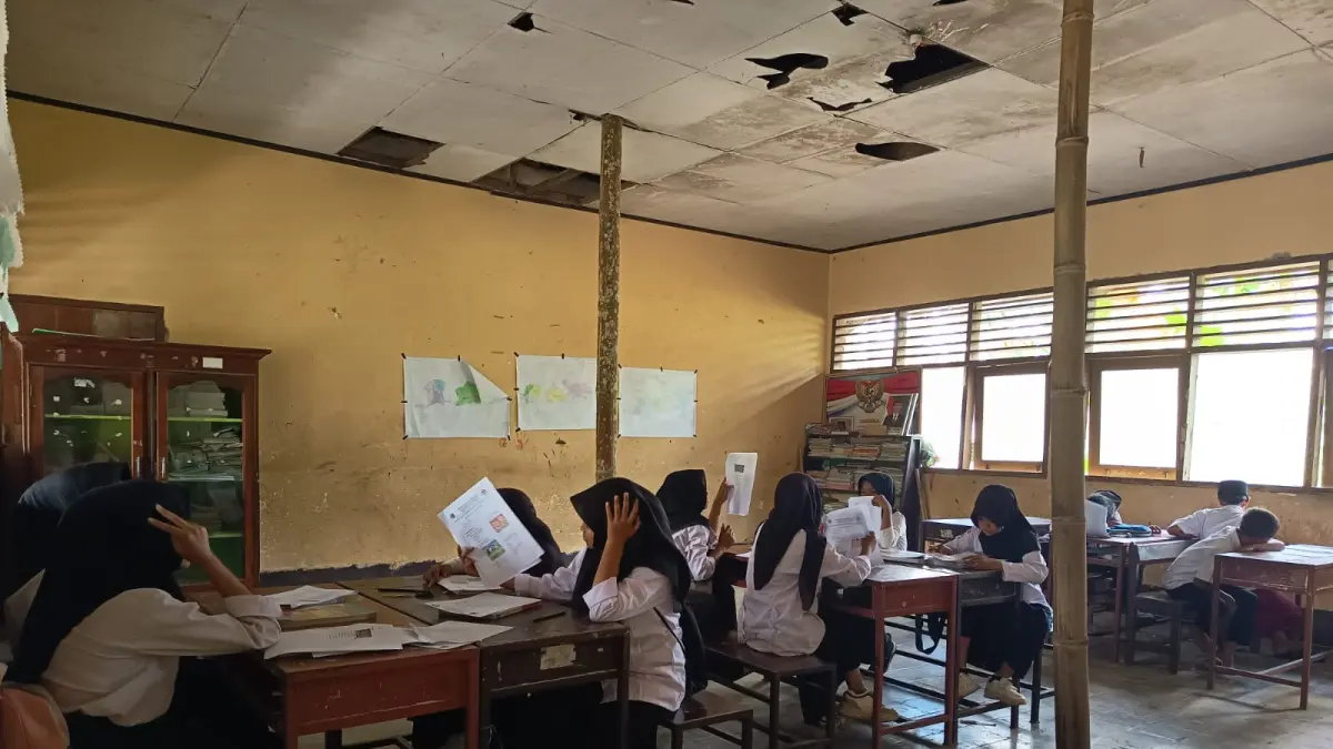 SISWA UJIAN: Sejumlah siswa kelas VI saat melakukan penilaian akhir tahun di ruangan kelas yang nyaris ambruk