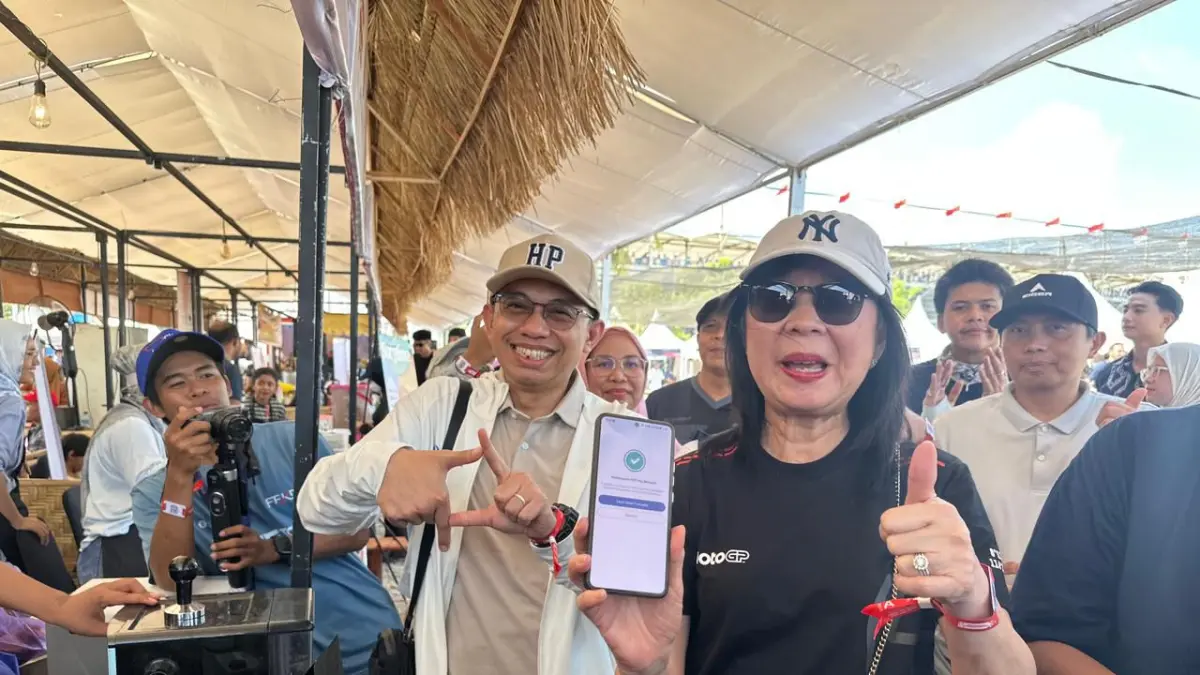 PERMUDAH TRANSAKSI: Deputi Gubernur Bank Indonesia Filianingsih Hendarta (kanan) didampingi KPwBI NTB Hario K Pamungkas menunjukkan bukti transaksi menggunakan QRIS Tap di stan UMKM MotoGP Mandalika, tahun lalu. (BI NTB for Lombok Post)