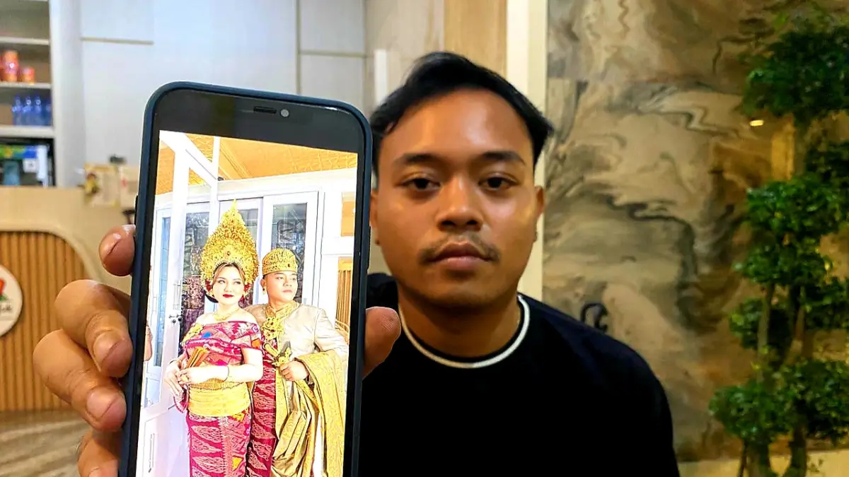 TUNJUKKAN FOTO:&nbsp; I Made Putra Arthawan, warga Desa Penimbung Lombok Barat menunjukkan foto istrinya inisial VN.