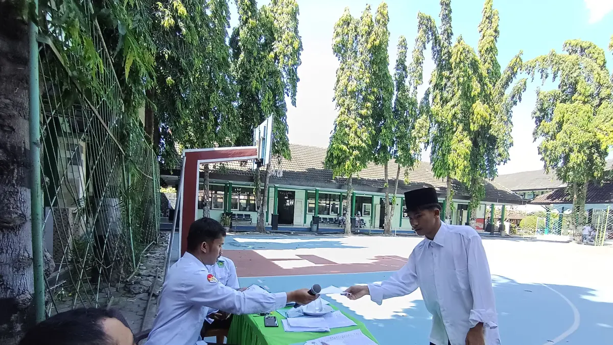 TES MASUK: Seorang calon siswa MAN 1 Lotim sedang mengambil berkas untuk dibawa ke ruangan tes baca alquran MAN 1 Lotim