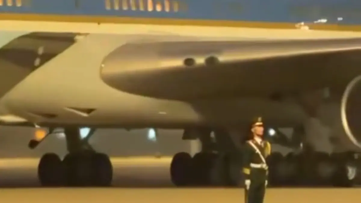 Donald Trump tiba di Beijing dengan Air Force One, sementara seorang prajurit Tentara Pembebasan Rakyat China (PLA) tetap berdiri tegak meski mesin pesawat mengaum keras di belakangnya.