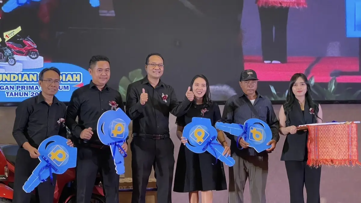 Direktur BPR Prima Nadi I Gusti Ketut Sri Putranta (tengah) menyerahkan hadiah sepeda listrik pada pemenang undian melalui perwakilan cabang. 