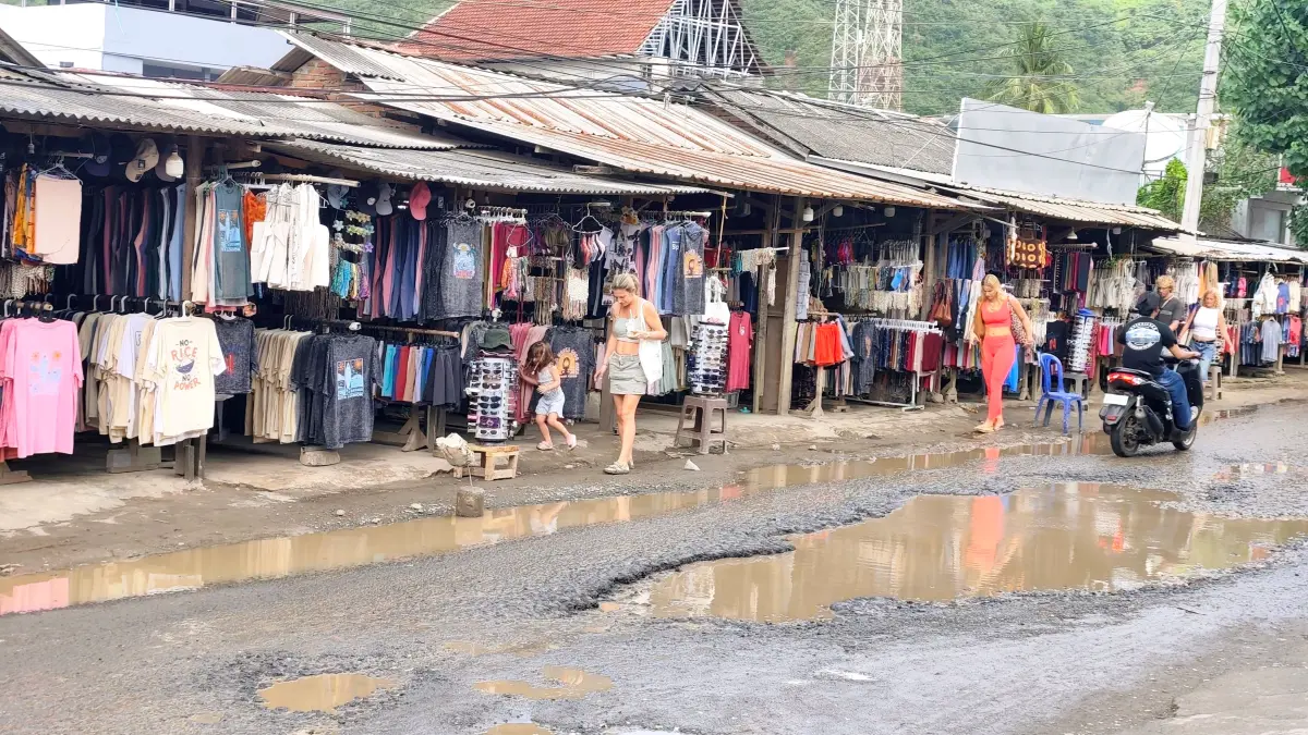 Sejumlah wisatawan mancanegara melintasi jalan raya wisata Kuta Lama yang berlubang dan becek di Desa Kuta, Pujut, Loteng, Selasa (19/5). (Dewi/Lombok Post) 
