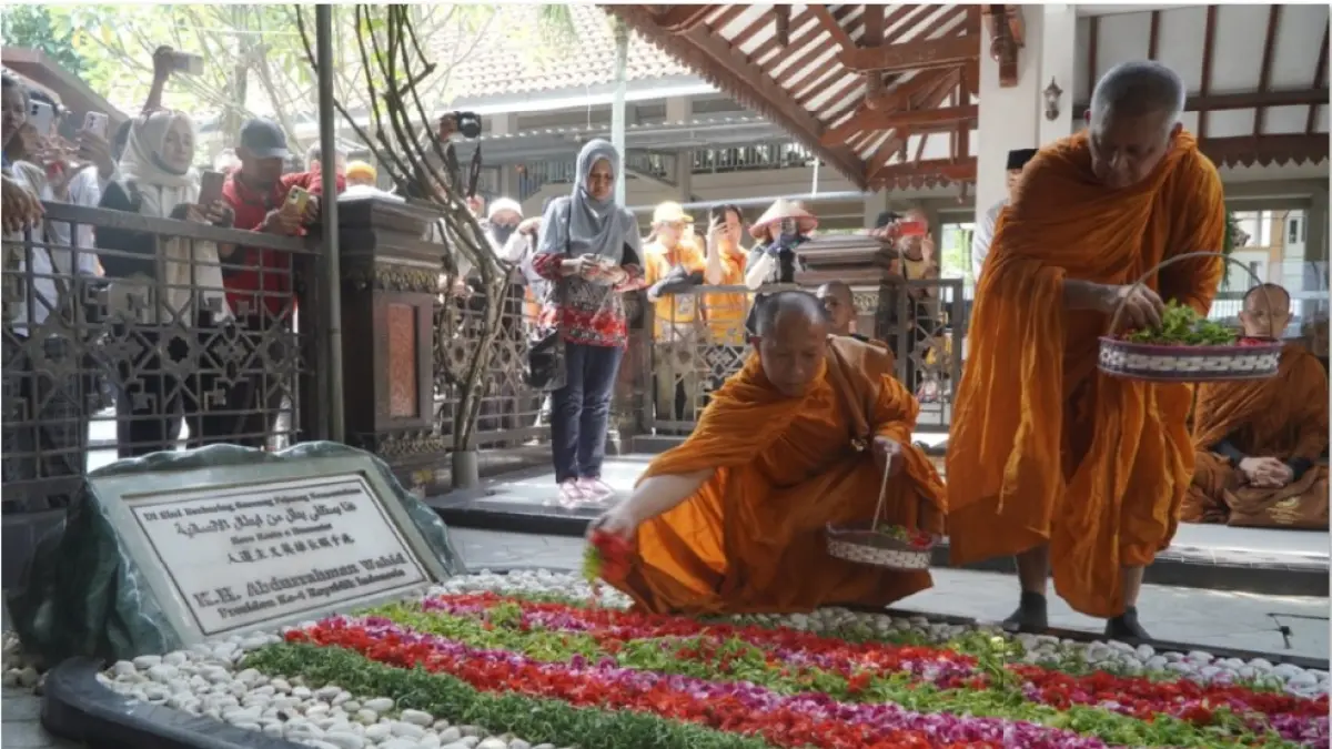 ZIARAH: Dua biksu berdoa dan menaburkan bunga ke makam Gus Dur di kompleks Pondok Pesantren Tebuireng, Kecamatan Diwek, Jombang, Jawa Timur, Selasa (19/5). (JAWA POS)