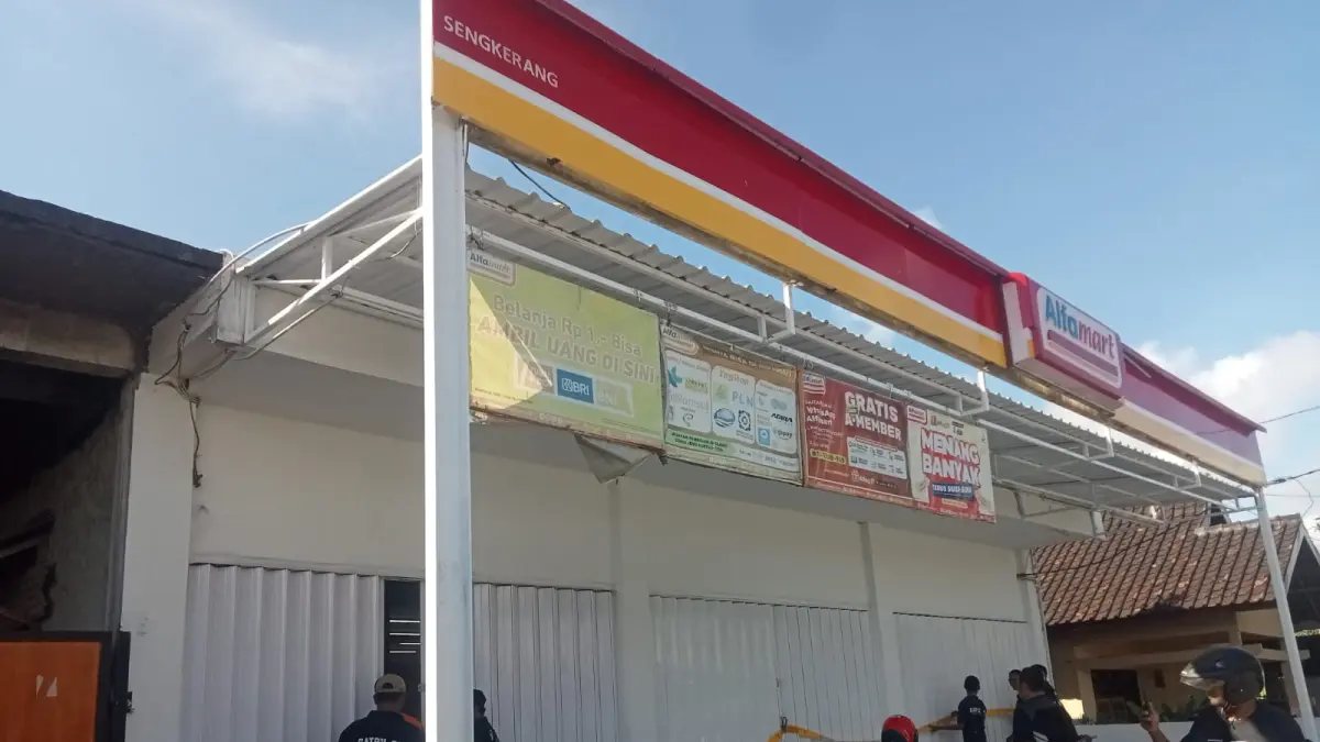 Petugas Satpol PP Lombok Tengah memasang tapi pita kuning kepada gerai Alfamart dan Indomaret yang membandel, Jumat (22/5). 