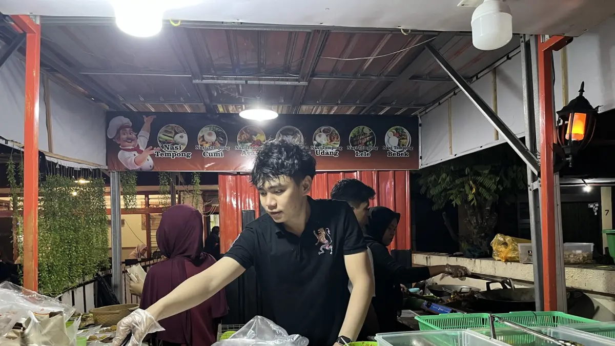 UMKM SUKSES: Owner Cimol Bojot AA Apis Adrian tengah melayani pesanan konsumen di gerai barunya yang ada di seberang Museum NTB, di Mataram. (Ferial/Lombok Post)