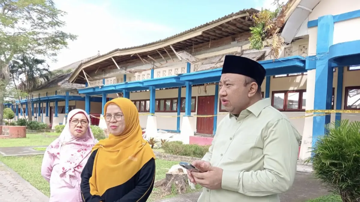 Wakil Ketua Komisi X DPR RI Lalu Hadrian Irfani didampingi Kepala Sekolah SMAN 7 Mataram Ridha Roslina (tengah) mengecek kondisi ruang kelas ambruk, Jumat (22/5).