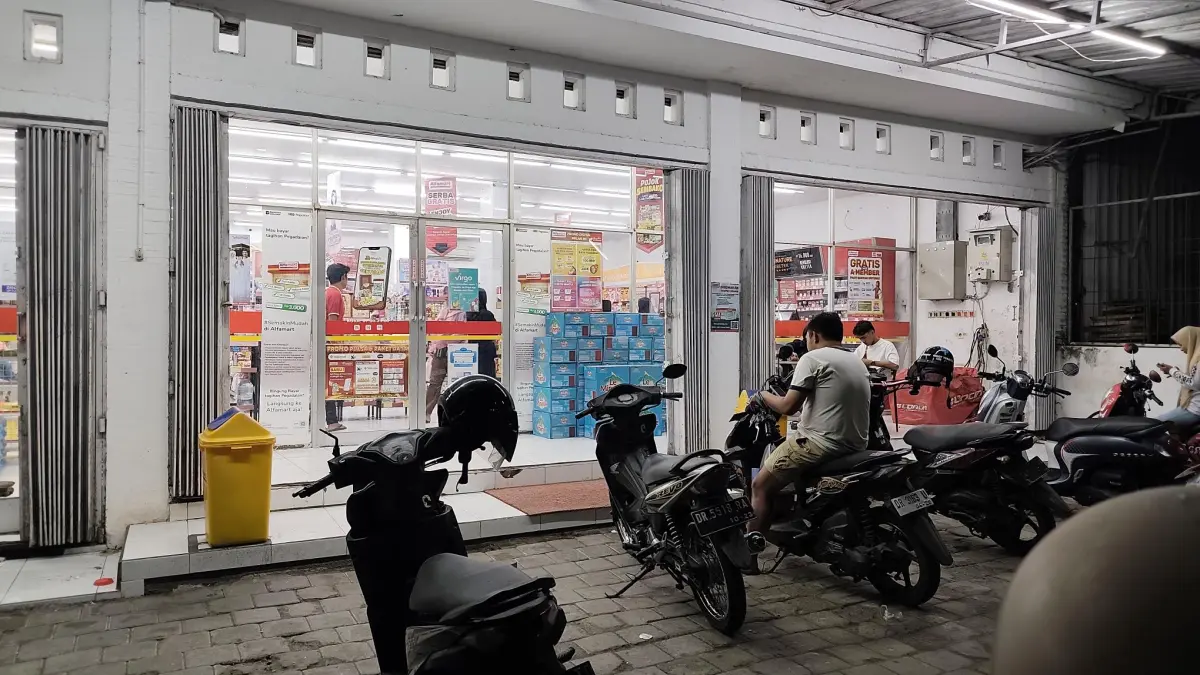Abaikan pita kuning, gerai Alfamart yang berlokasi dekat Pasar Renteng tetap beroperasi melayani konsumen, di Lombok Tengah, Selasa (26/5). (Dewi/Lombok Post) 