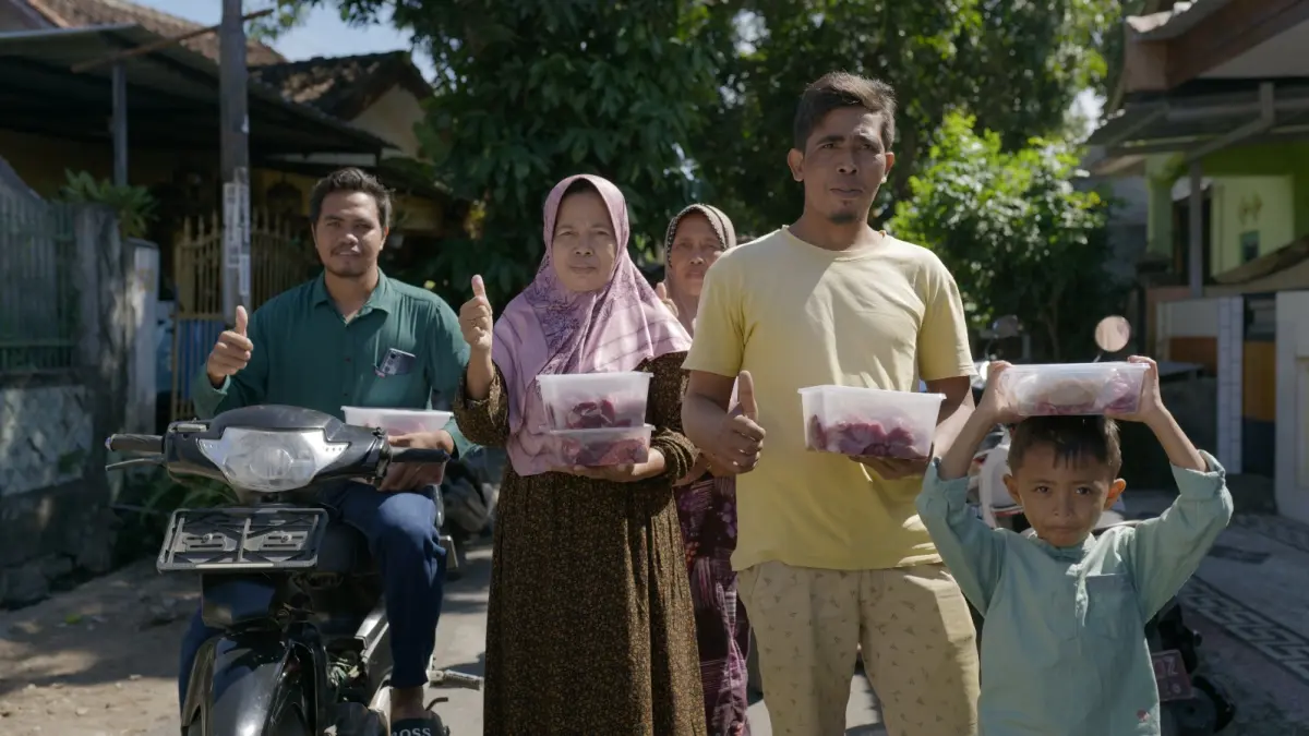 Warga menerima daging kurban yang didistribusikan lembaga kemanusiaan Islamic Relief Indonesia, Rabu (27/5).