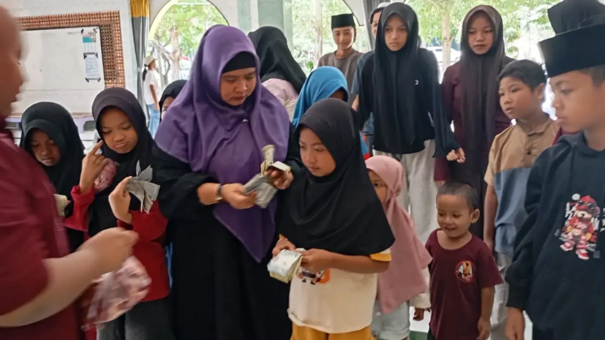 BERBAGI: Kepala SMAN 3 Mataram Yuspita Martiningrum (jilbab ungu) memberikan santunan dan daging kurban kepada anak yatim di sekolah setempat, Kamis (28/5).


