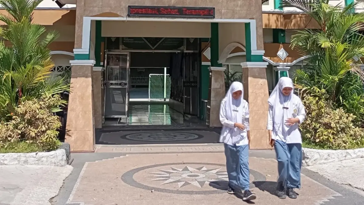 MEMBANGGAKAN: Dua siswa MAN 1 Mataram berjalan di depan pintu masuk madrasah setempat, Selasa lalu (26/5). Tahun ini, 87 Siswa MAN 1 Mataram Lulus SNBT.