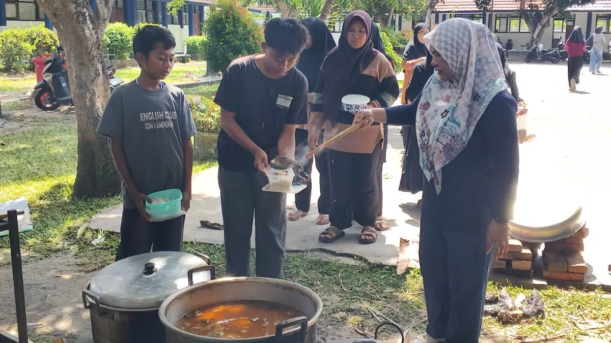 PENERIMA MANFAAT: Siswa SMPN 21 Mataram menerima daging kurban yang dimasak di sekolah setempat, Kamis (28/5).