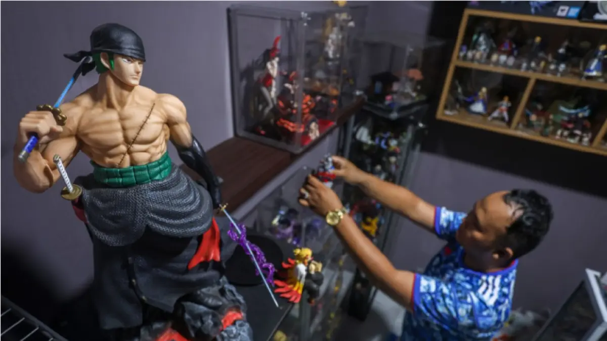 TELATEN: Yuda Farizki merawat action figurenya satu per satu dengan telaten. (IVAN/LOMBOK POST)