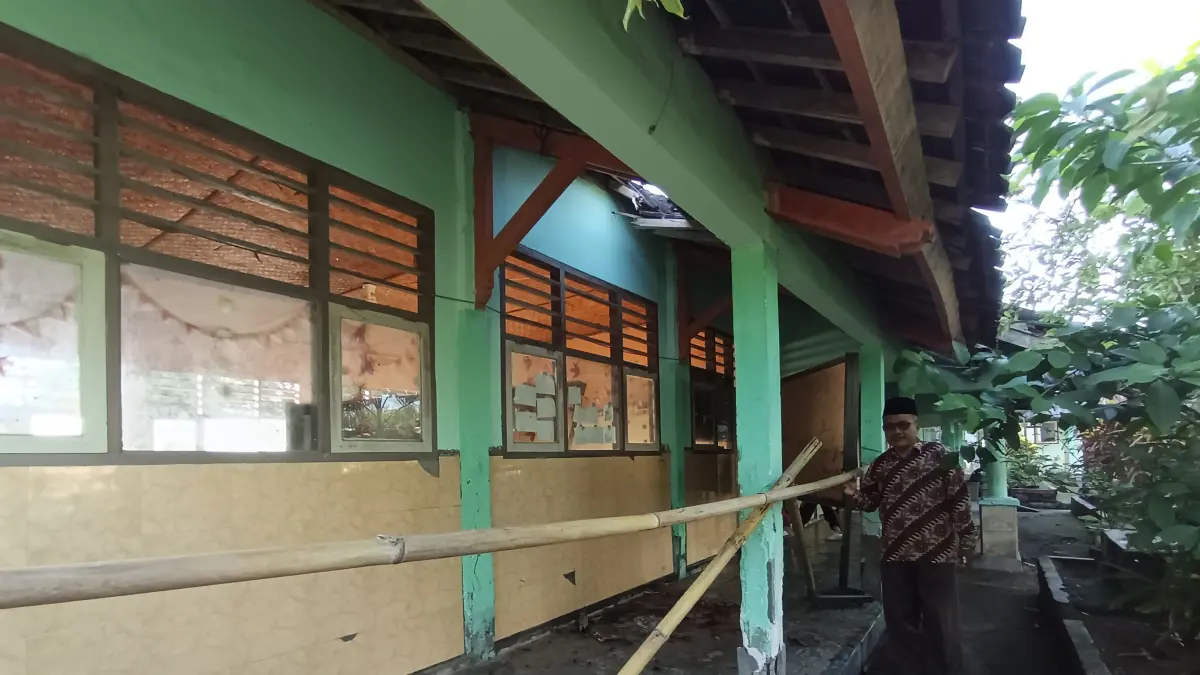 BANGUNAN RUSAK: Muhyi kepala sekolah SDN 1 Jerowaru saat melihat kondisi bangunan yang mulai berjatuhan gentengnya. 
