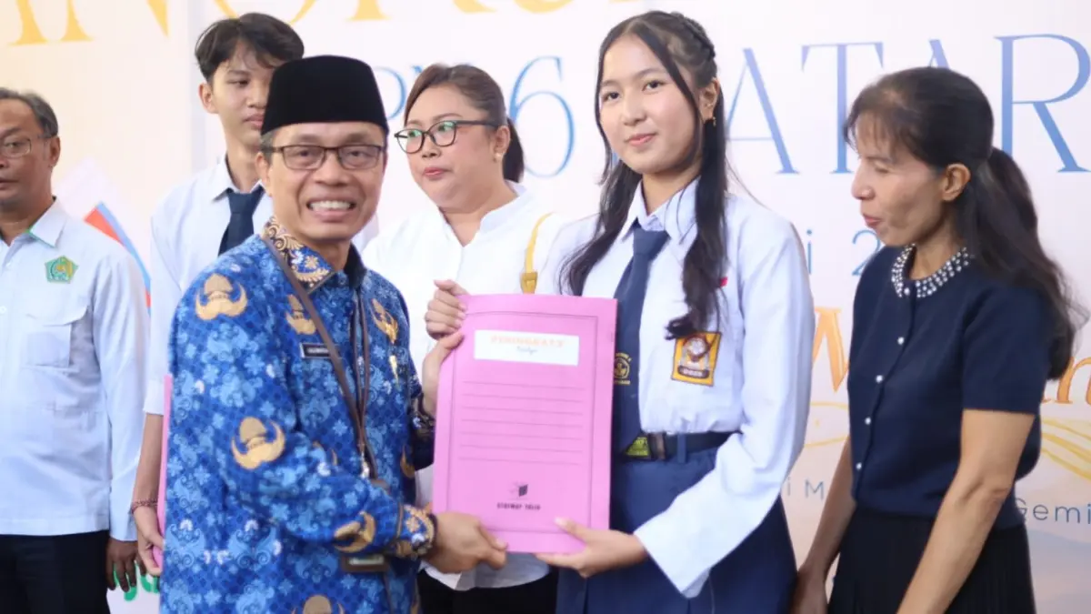 DIAPRESIASI: Plh Disdik Kota Mataram Lalu Martawang memberikan apresiasi kepada siswa SMPN 6 Mataram yang meraih nilai TKA tertinggi pada acara pelepasan siswa kelas IX di sekolah setempat, Selasa (2/6).