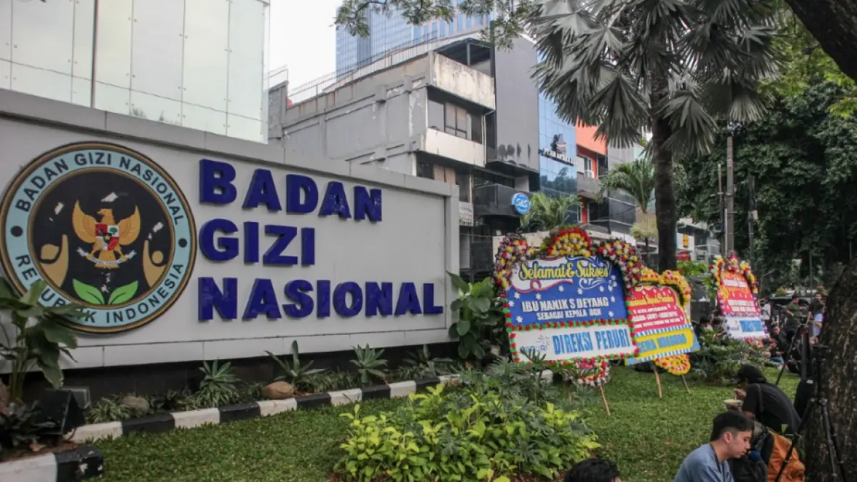TAK BISA KERJA: Aktivitas sejumlah pegawai di depan kantor Badan Gizi Nasional (BGN) di Jakarta saat Penyidik Jaksa Agung Muda Tindak Pidana Khusus (Jampidsus) Kejaksaan Agung melakukan penggeledahan di kantor BGN pada Rabu (3/6). (HANUNG HAMBARA/JAWA POS)