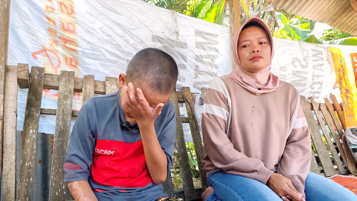 INGIN KEMBALI SEKOLAH: Didampingi bibinya (kanan) tangis SA pecah saat mengingat kejadian dugaan pembakaran yang dilakukan oknum kakak kelasnya, Kamis (4/6). (Dewi/Lombok Post) 