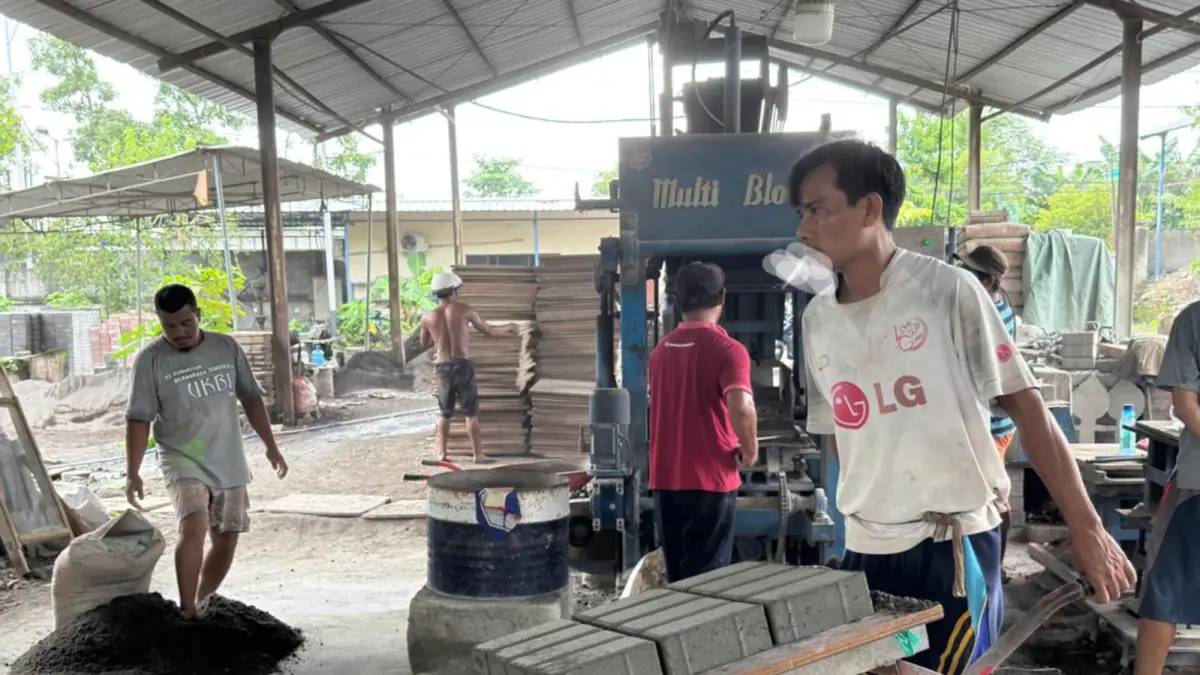 OPERASIONAL BUMD: Para pekerja PT GNE saling bekerja sama, memproduksi paving block, beberapa waktu lalu. (YUYUN/LOMBOK POST)