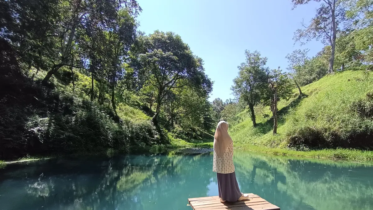 MENIKMATI: Seorang pengunjung sedang menikmati keindahan alam di destinasi wisata air Telaga Biru, Desa Perian, Kecamatan Montong Gading, Lombok Timur