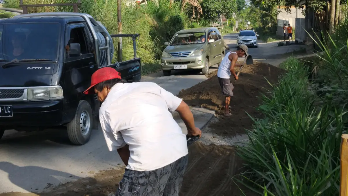 TIMBUN: Salah seorang pelaku wisata di Desa Tetebatu bersama warga saat menimbun jalan kabupaten yang rusak yang ada di Desa Tetebatu Selatan menuju Kotaraja.