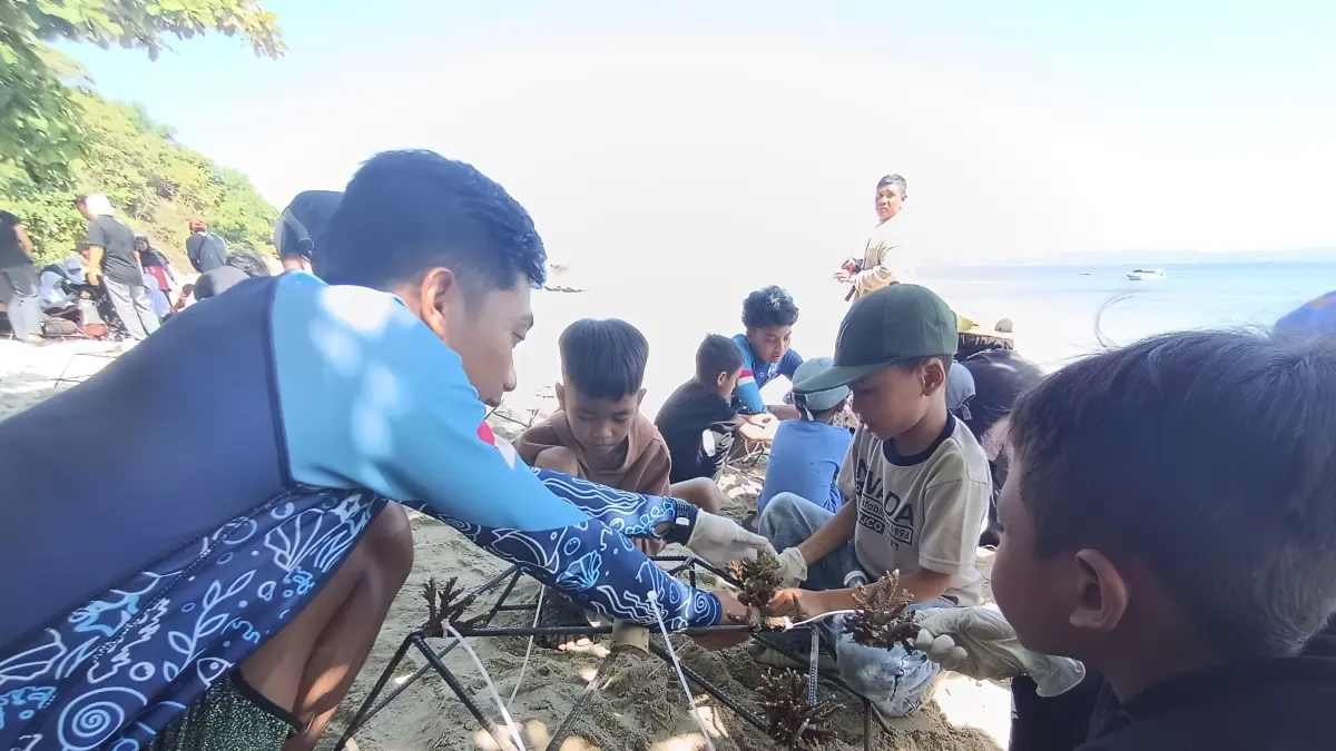 UNTUK LINGKUNGAN: Resot Manager Innit Lombok bersama anak-anak Dusun Berita, Desa Ekas saat mengikat terumbu karang sebelum dilepas di laut pada acara peringatan Hari Laut Sedunia