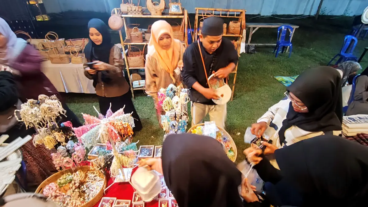 Para remaja putri berburu pernak-pernik cantik di salah satu stand Serambi Kuliner yang hadir di venue utama MTQ NTB 2026 ke-31 di Bencingah Agung Masmirah, Loteng, Selasa (9/6) lalu. (Dewi/Lombok Post) 