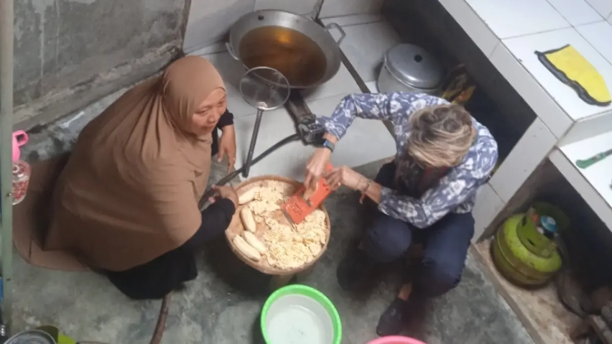 COBA MEMASAK: Khaeriah, ketua Kelompok Usaha Desa Kembang Kerang, menunjukkan cara membuat keripik pisang pada Konsul Jenderal Konjen Australia di Bali Joe Steven, Rabu (10/6).