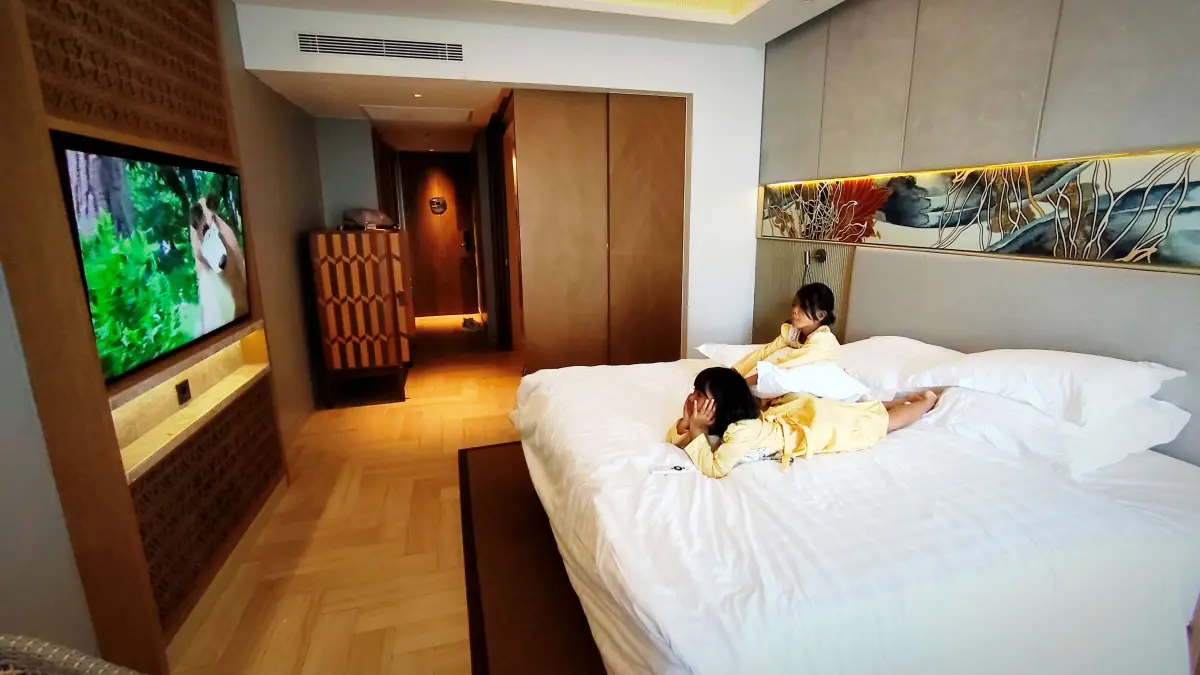 Dua orang anak kecil sedang bersantai sembari menonton televisi di dalam kamar Deluxe Pullman Lombok Merujani Mandalika Beach Resort, di Desa Kuta, Pujut, Loteng, Senin (15/6). (Dewi/Lombok Post) 