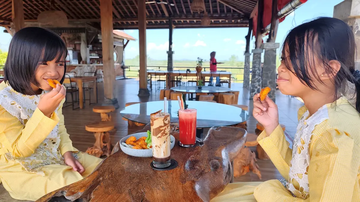 LEPAS PENAT: Dua anak perempuan sedang menikmati cemilan dan minuman segar yang disajikan Javalo Resto & Coffee Lombok, Desa Sukarara, Jonggat, Loteng. (Dewi/Lombok Post) 