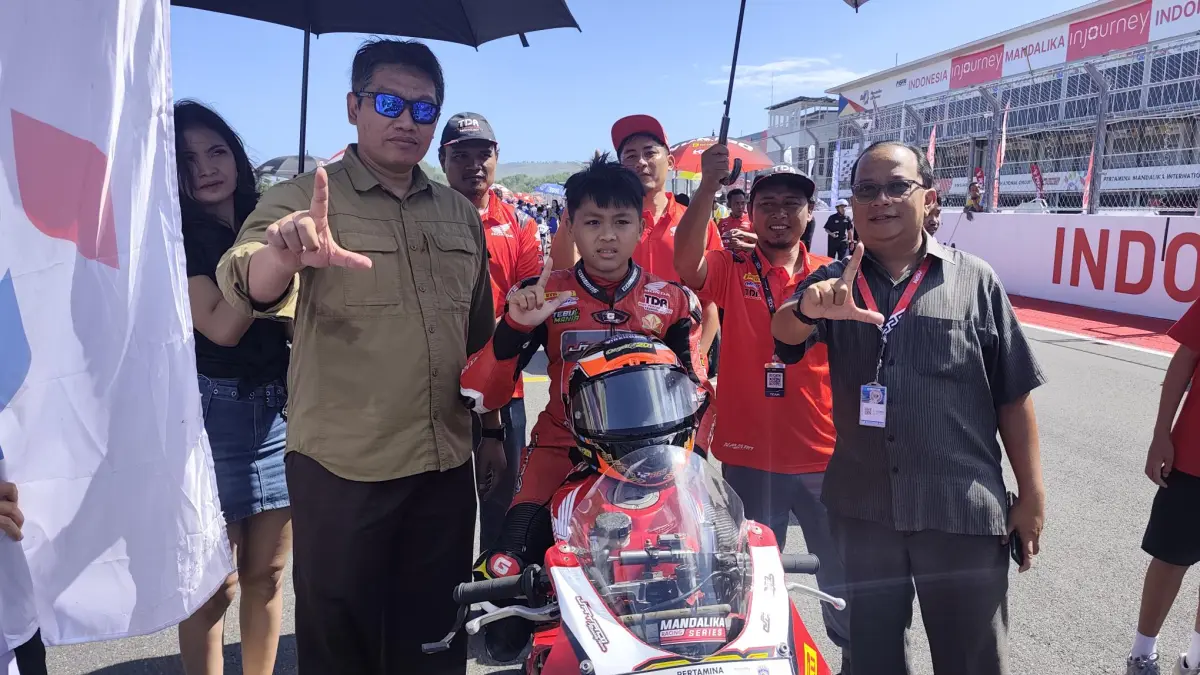 Kepala Dinas Pariwisata NTB Ahmad Nur Aulia (kiri) berfoto bersama sejumlah pembalap asal NTB di ajang Mandalika Racing Series 2026 Round 2 di Sirkuit Internasional Mandalika, Minggu (21/6). (Dewi/Lombok Post) 